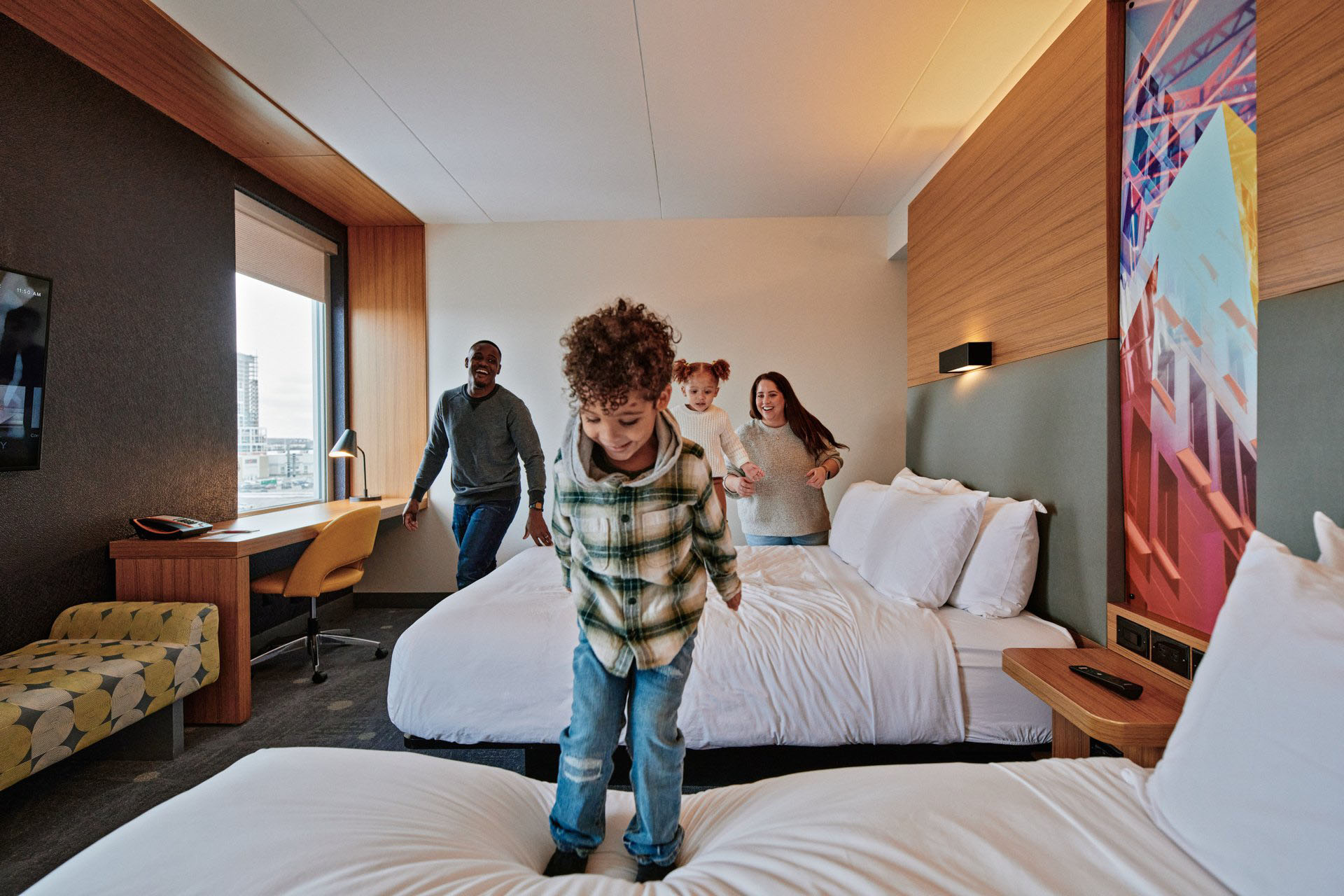Kid Jumping on Bed in Hotel Room