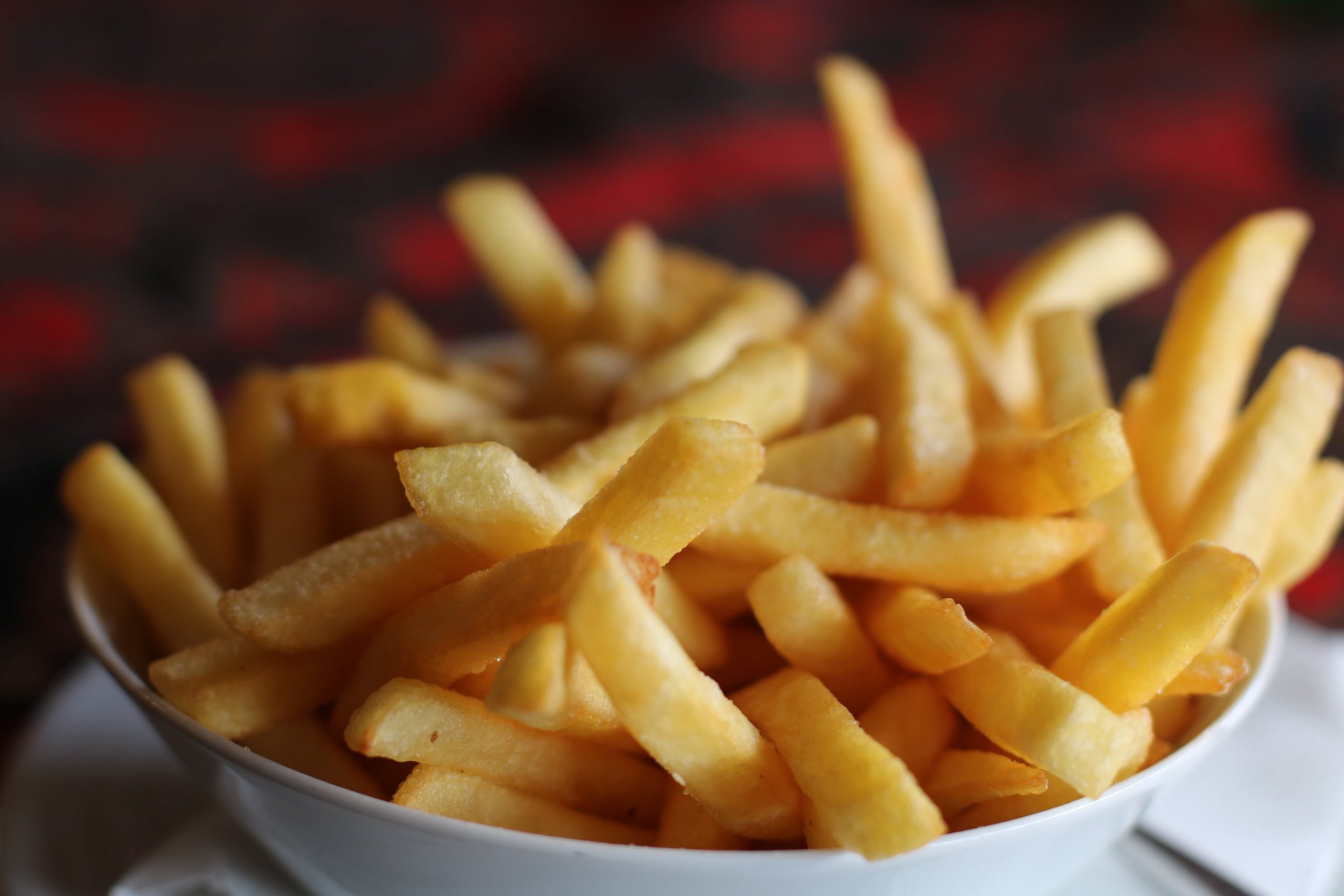 Close up of french fries in a white bowl.