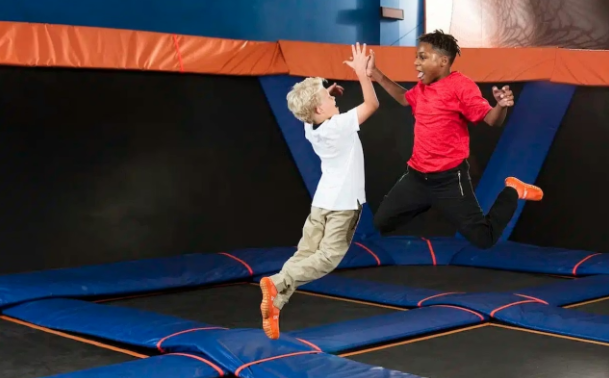 Image of two children bouncing in the air at an indoor trampoline park