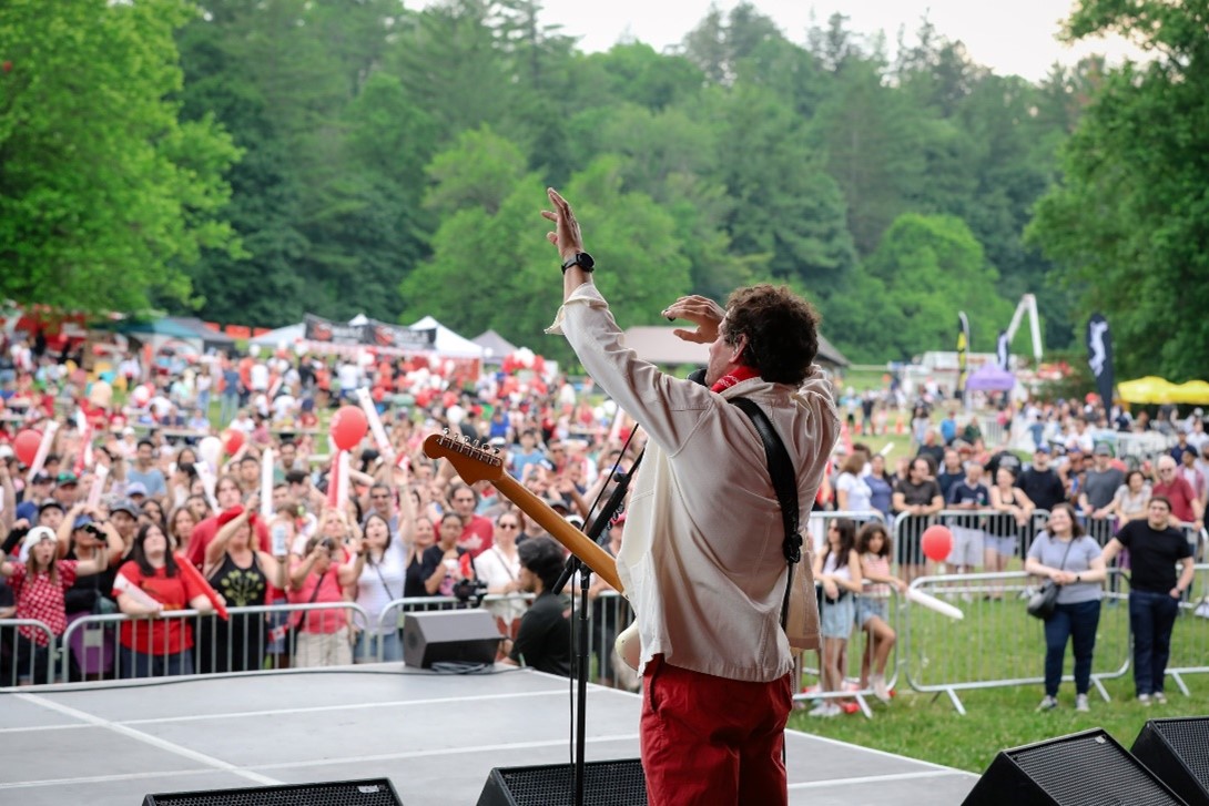 singer performing in front of a large crowd while on stage