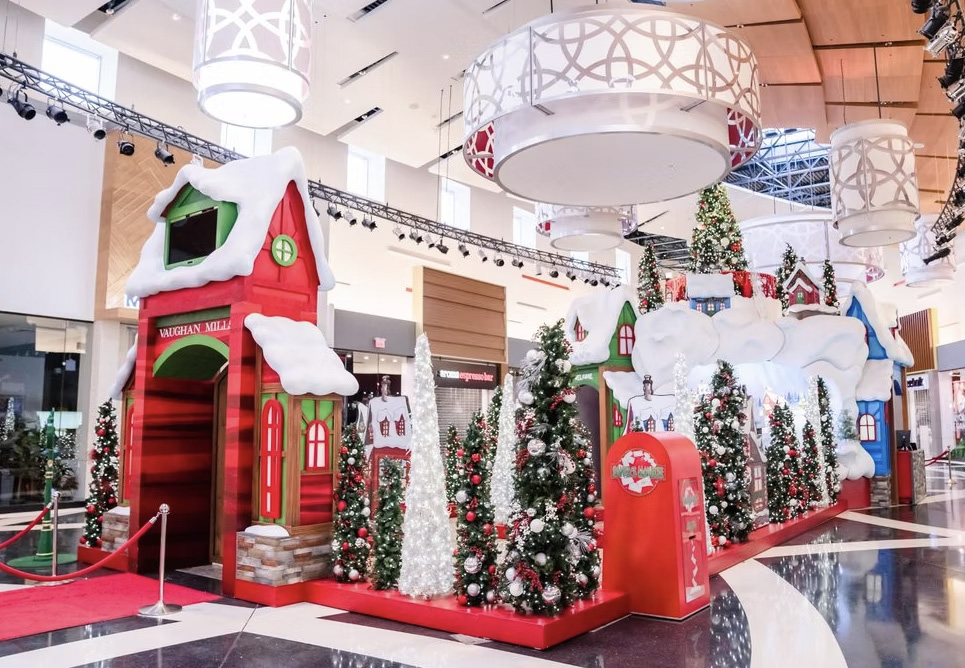 A Christmas display with red mini buildings and trees.