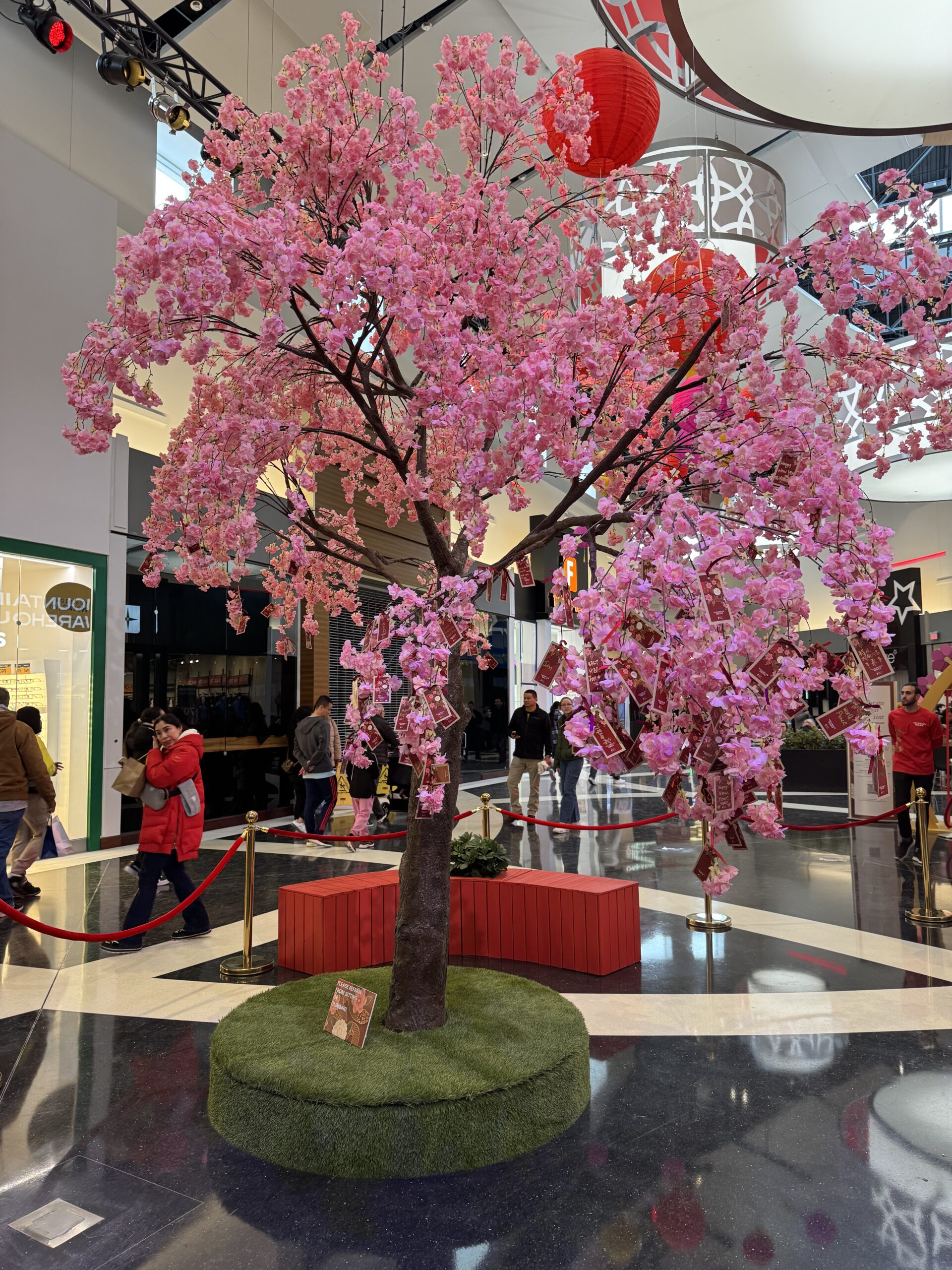 Imagine of a decorative tree inside a mall with pink cherry blossoms