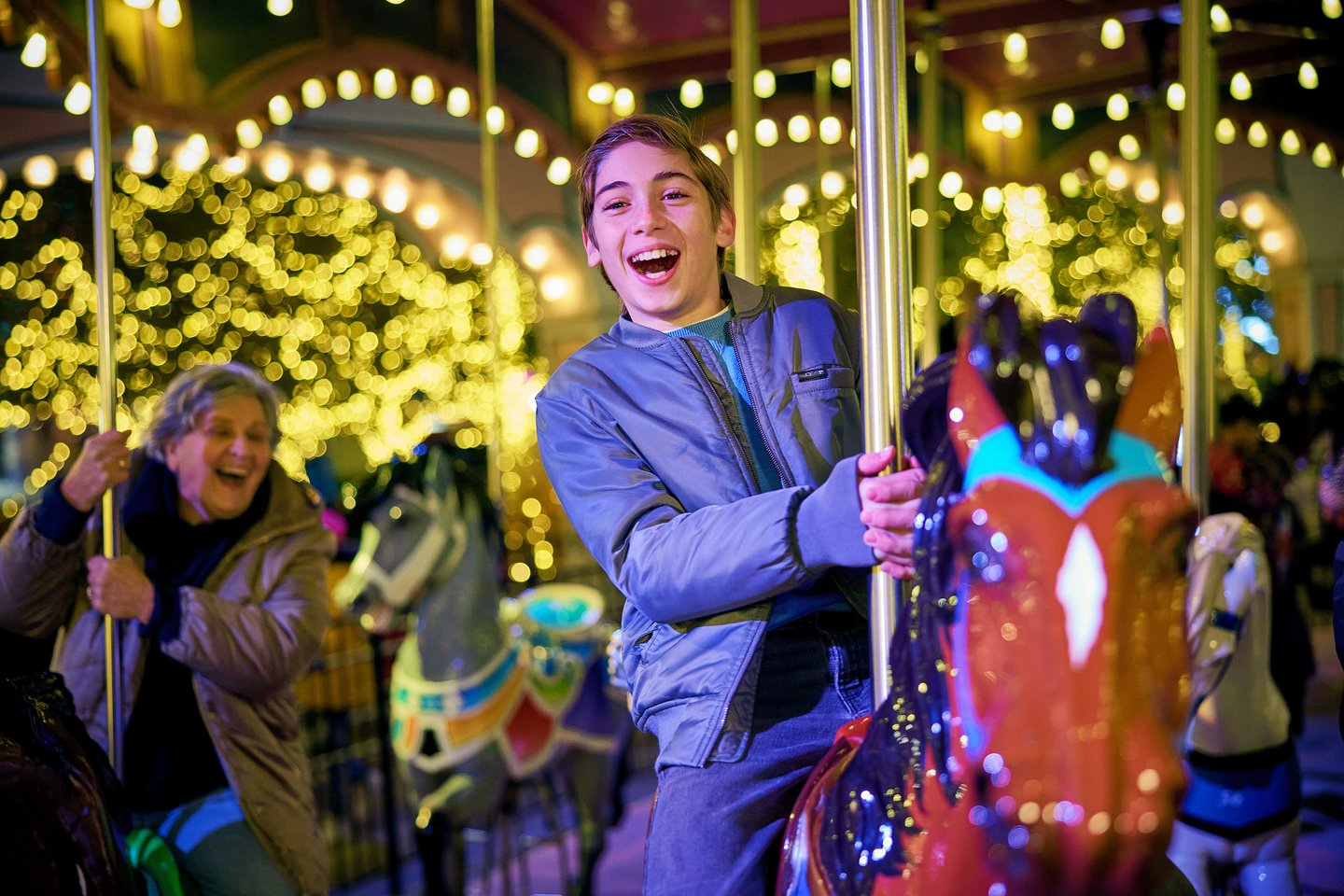 Image of an excited child riding a carousel at night