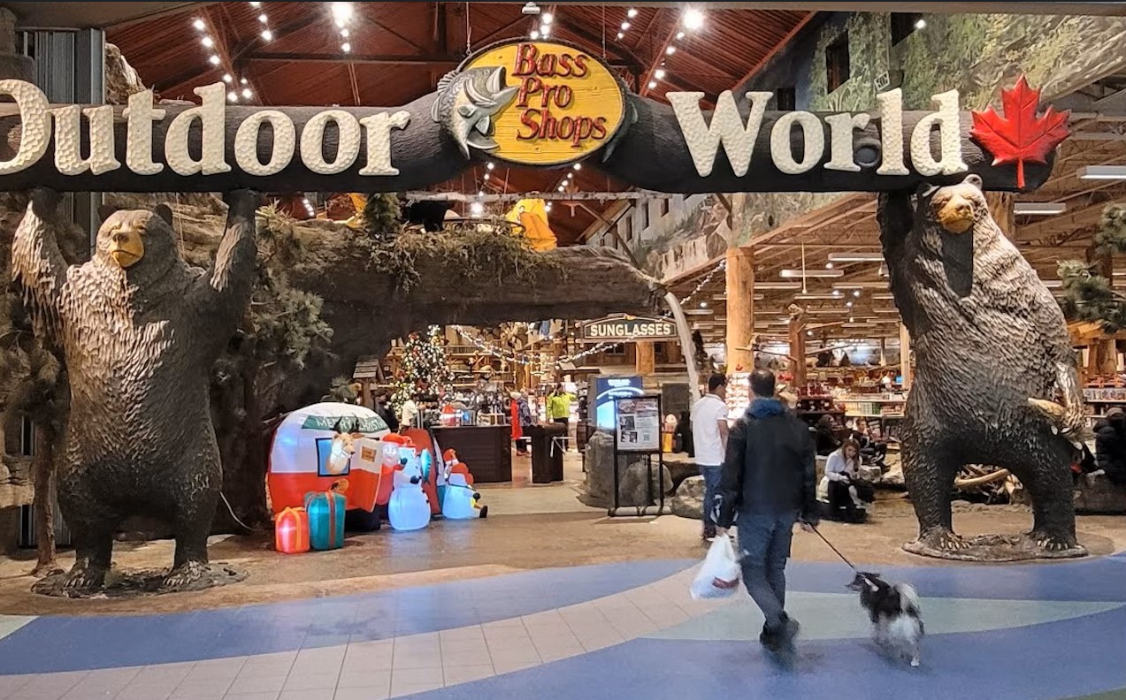 Image of the entrance of Bass Pro Shop with a person walking in