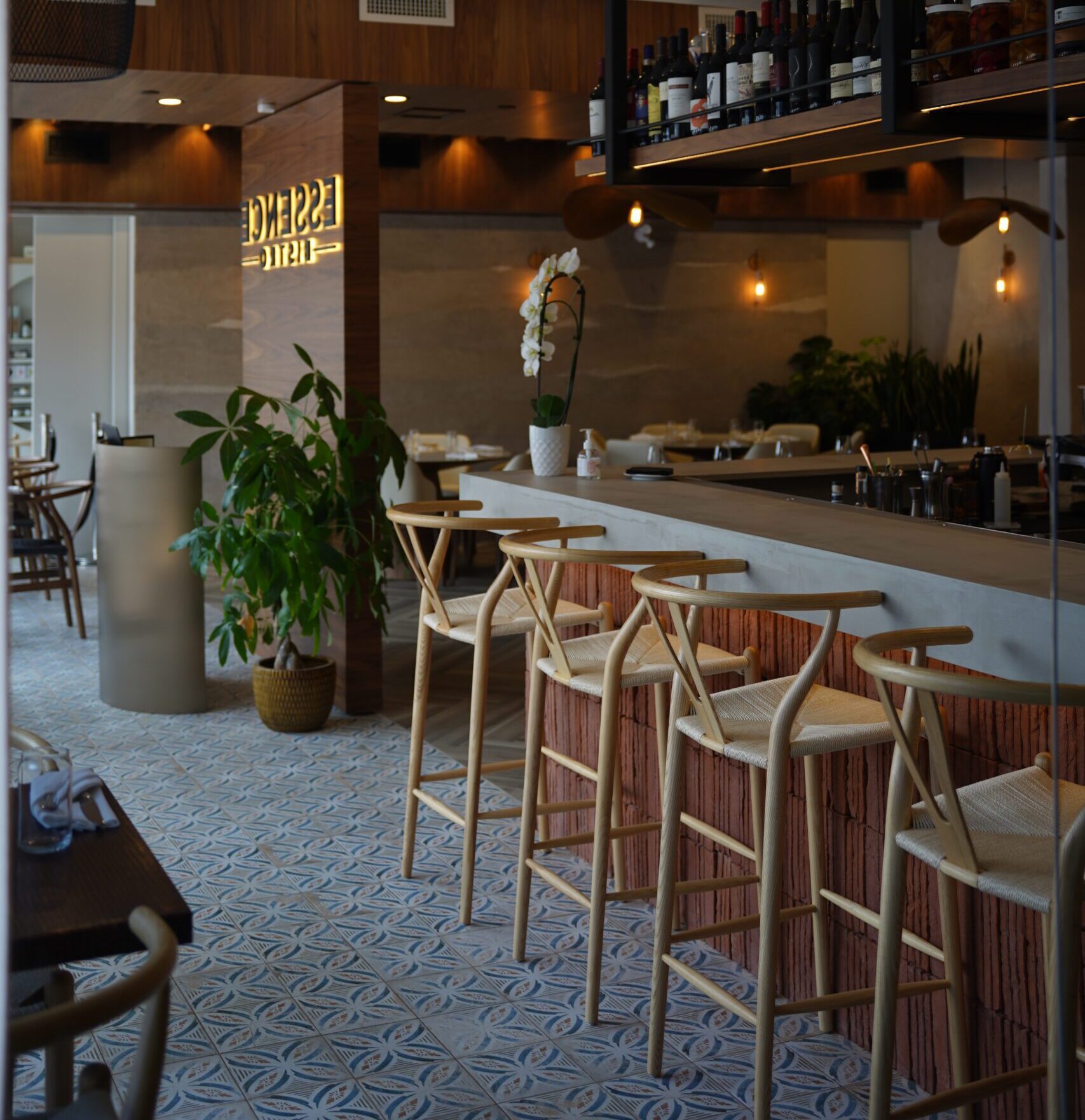 Image of the interior of a beautifully designed restaurant with a long bar and several stools