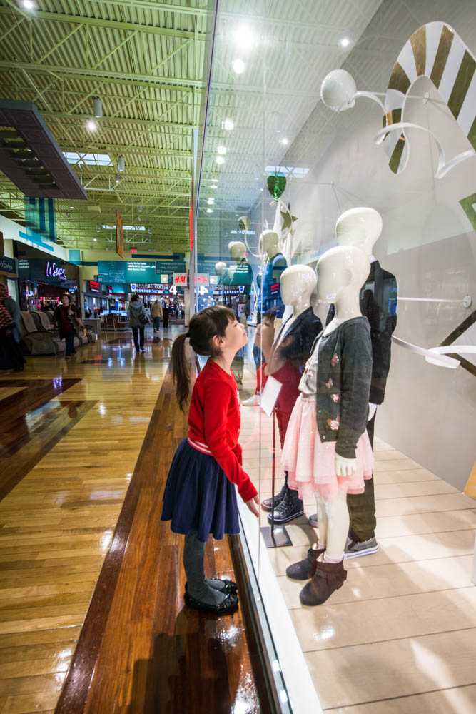 Image of a child looking at manikins in a shop window