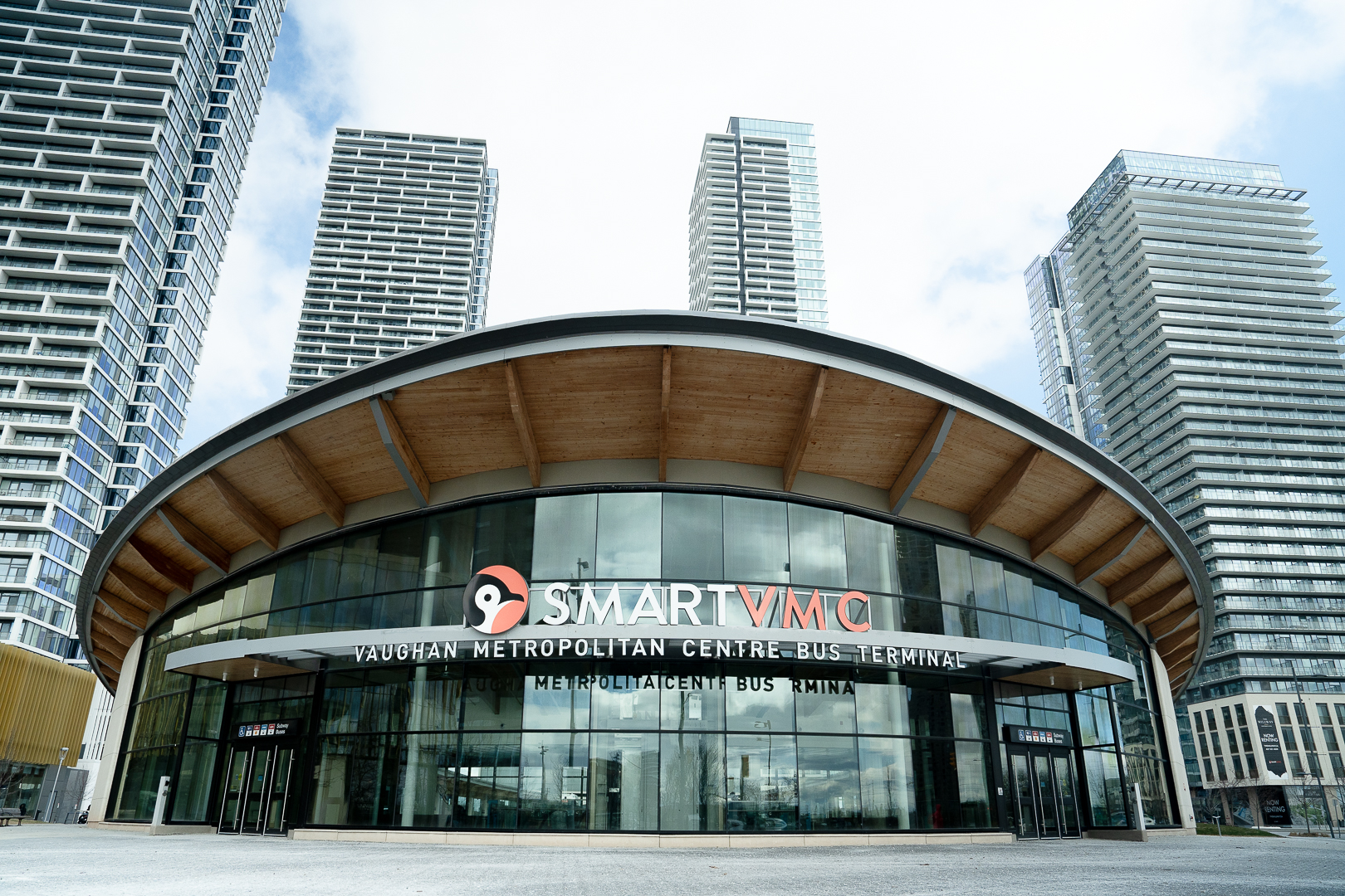 Image of an urban bus terminal with skyscrapers behind