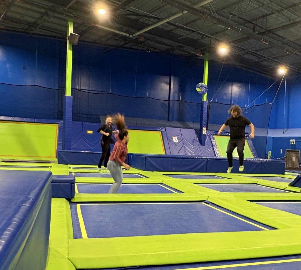 Image of three people jumping at an indoor trampoline park
