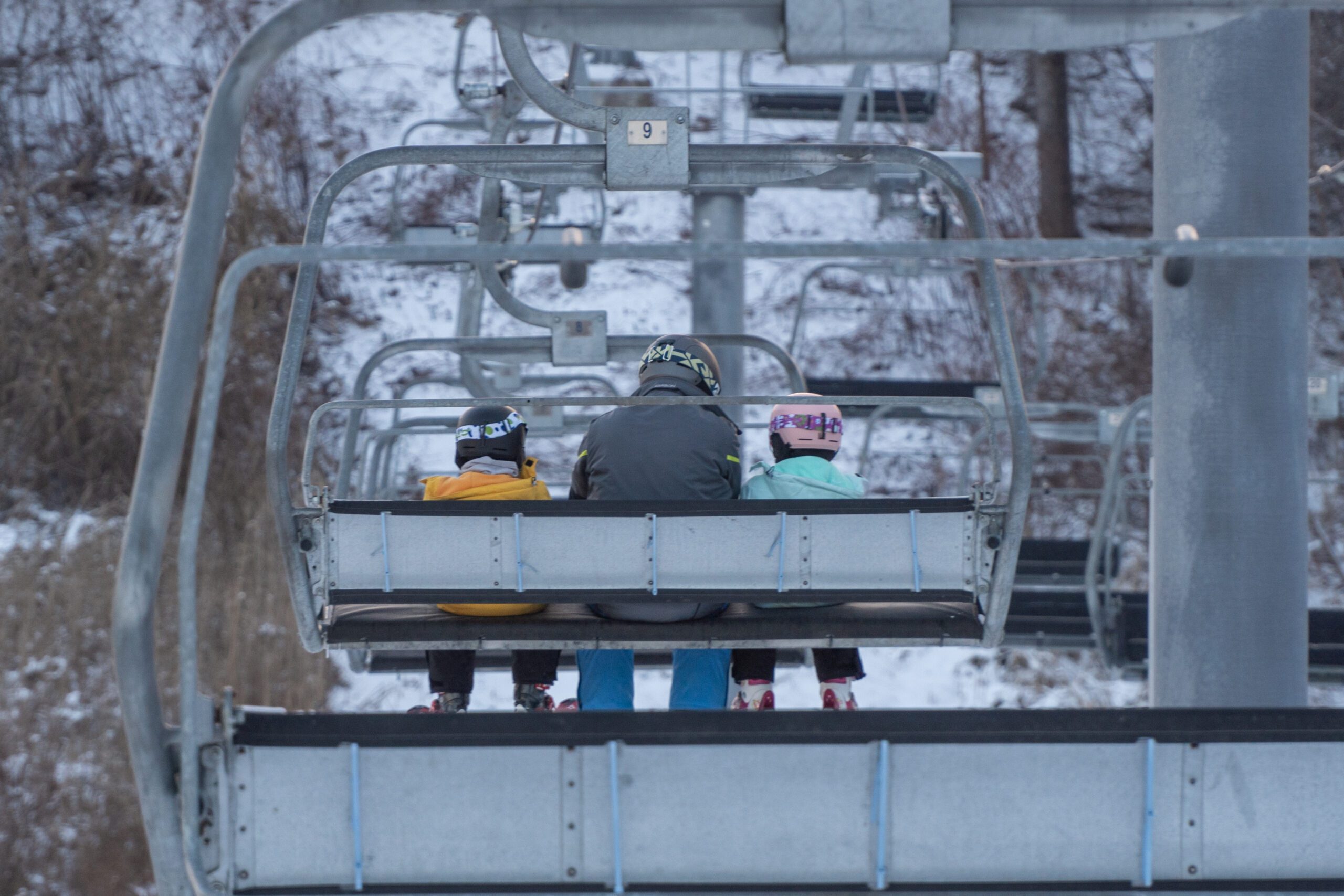 Image of a family riding a chair lift at a ski hill