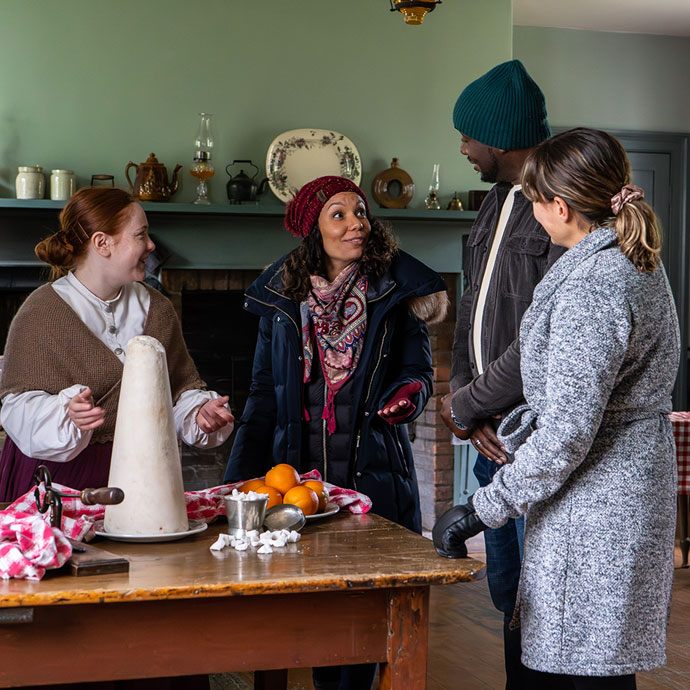 Image of a family visiting a museum village chatting with an interpreter