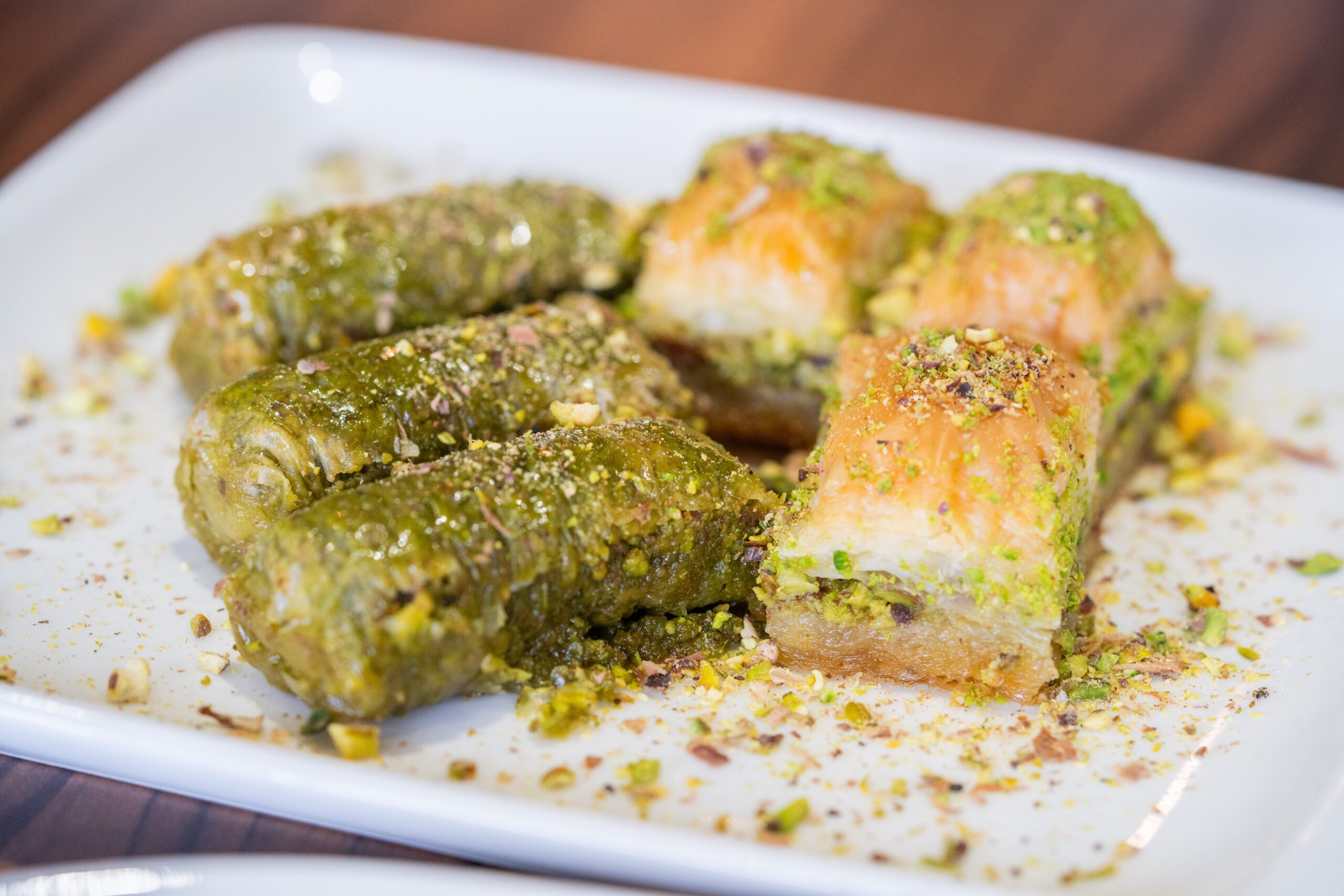 Image of crispy phyllo pastries on a plate topped with chopped pistachios