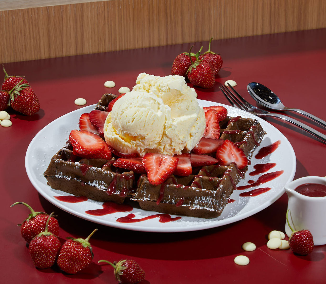 Image of a chocolate waffle topped with sliced strawberries and vanilla ice cream