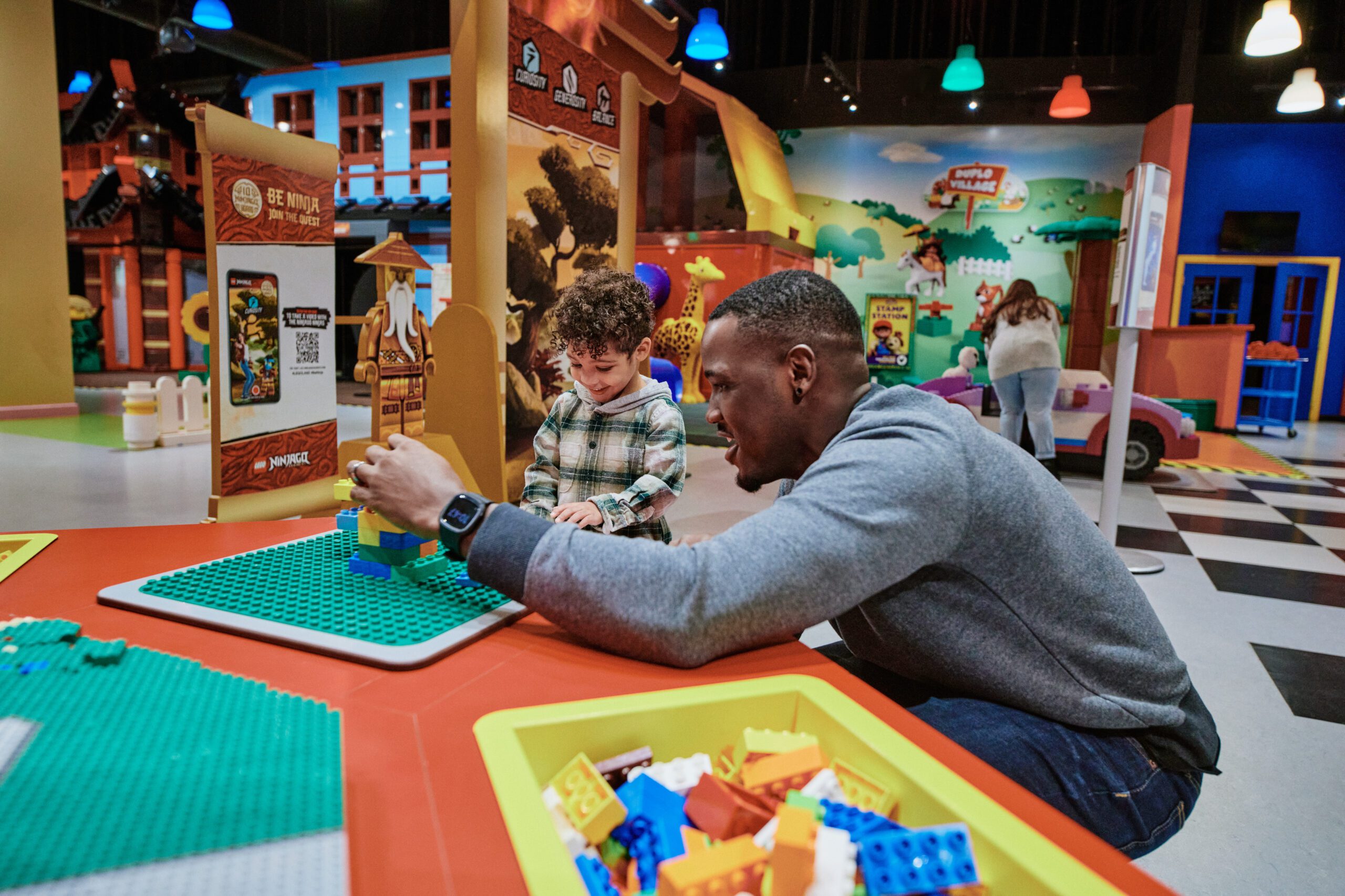 Image of a parent and their child having a good time playing with building blocks
