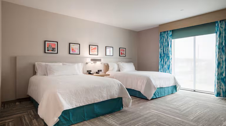 Image of the interior of a hotel room with two beds