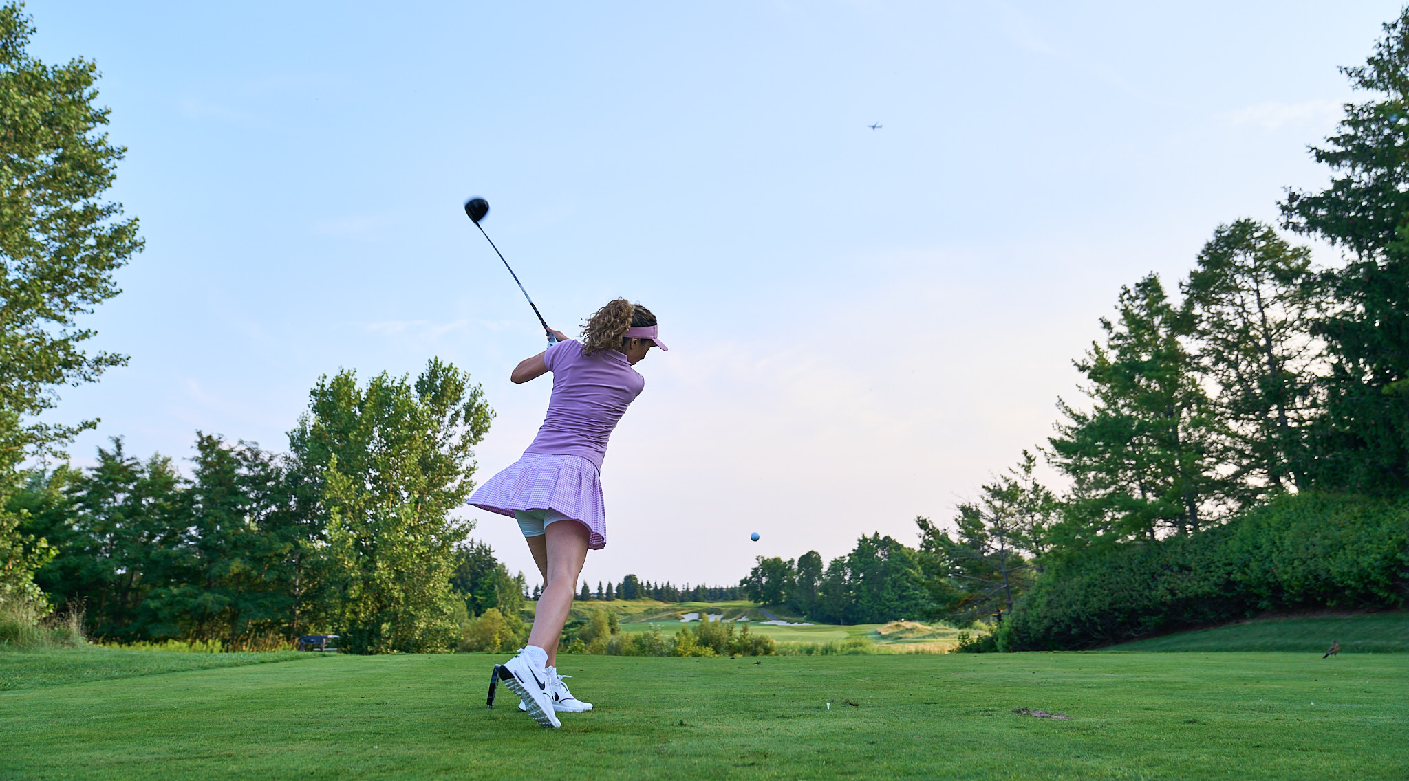 person swinging golf club